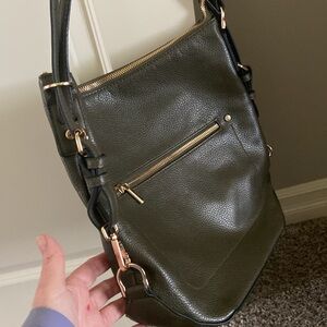 A new day Olive hobo style handbag. 12”x12”. Brass hardware. Zip top.